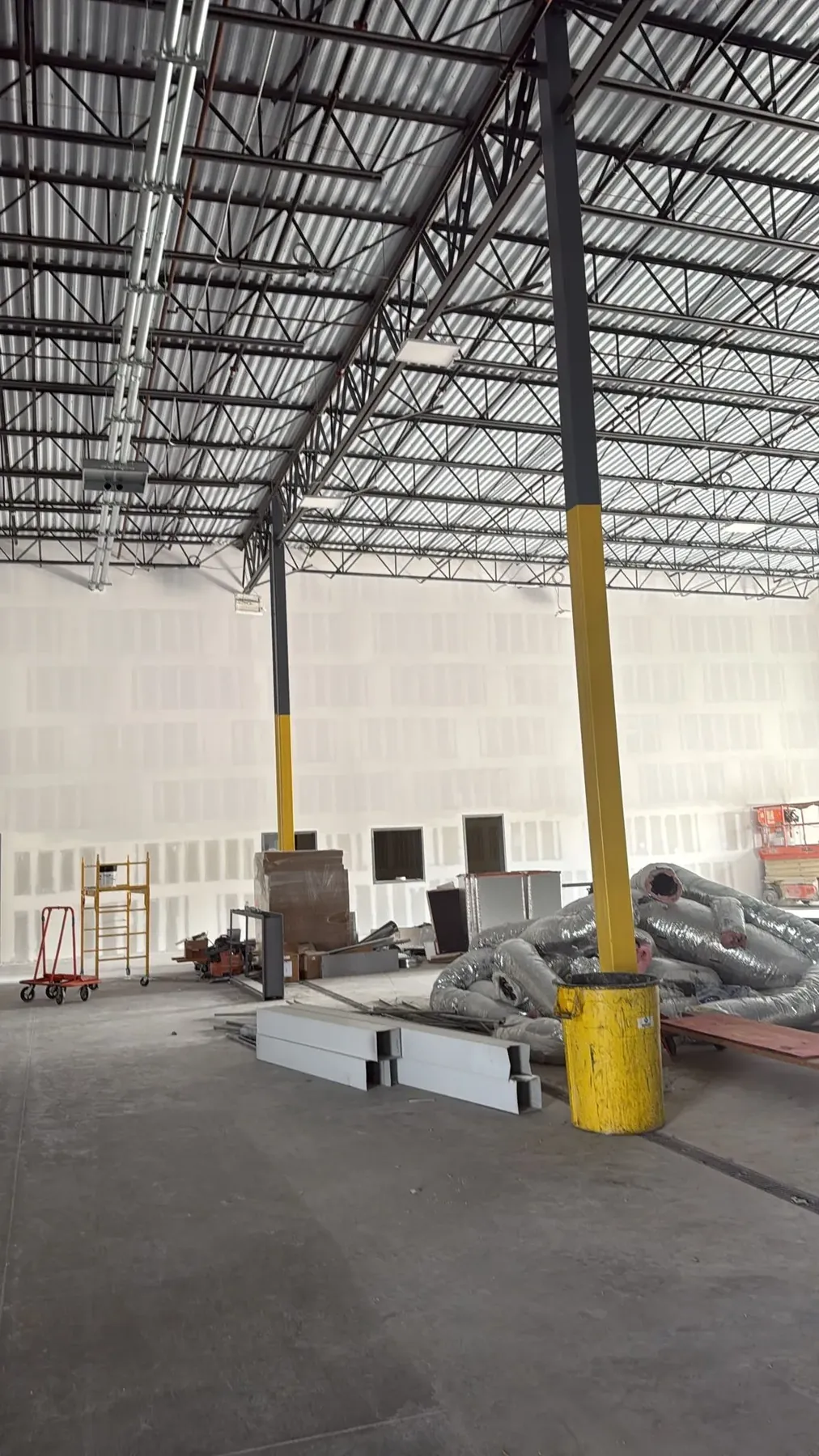 Drywall hung and taped on tall warehouse walls